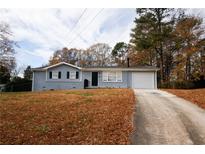 Charming single-story home with a driveway, attached garage, and front yard at 5760 Lakeview Dr, Powder Springs, GA 30127
