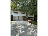 Ranch style home with two-car garage and mature landscaping at 4681 Mercer Rd, Stone Mountain, GA 30083