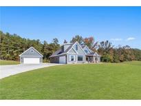 Gray farmhouse exterior with attached garage and expansive lawn at 101 Red Oak Ln, Carrollton, GA 30116