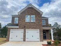 Two-story brick home with a two-car garage and landscaped yard at 620 Egrets Landing Lot #68 Lndg, Covington, GA 30014