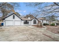 Ranch style home with a two-car garage and mature trees at 441 Village Way, Lawrenceville, GA 30046