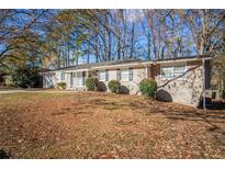 Ranch style home with a spacious lawn and mature trees at 2496 Montezuma Cir, Ellenwood, GA 30294