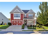 Charming two-story red home with a welcoming front porch and attached garage at 100 Academy Ln, Canton, GA 30114