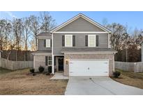 Two-story home with gray siding, brick accents, and a two-car garage at 153 Fresh Laurel Ln, Locust Grove, GA 30248