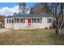 Charming ranch home with gray brick exterior, red door, and landscaped lawn at 1742 Lynn Ln, Decatur, GA 30032