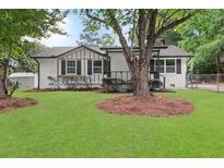 Charming ranch home with white brick exterior, gray accents, and a spacious lawn at 1396 Iron Gate Blvd, Jonesboro, GA 30238