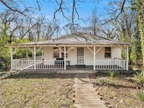 Charming white cottage with a wraparound porch and landscaped yard at 2259 Whites Mill Rd, Decatur, GA 30032