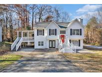 Two-story house with white siding, red door, and wraparound porch at 3563 Stratford, Douglasville, GA 30135