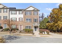Brick three-story townhome with front yard and driveway at 5667 Cascade Sw Run, Atlanta, GA 30336