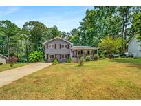 Two-story house with gray siding, red shutters, and a wooden porch at 3989 Woodland Se Cir, Conyers, GA 30013