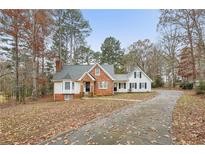 Brick ranch house with a long driveway, surrounded by trees with autumn leaves at 245 Brookclear Ln, Fayetteville, GA 30215