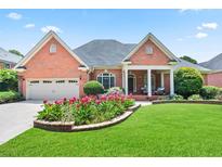 Brick house with landscaped yard and two-car garage at 5835 Sunset Maple Dr, Johns Creek, GA 30005