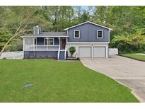 Newly painted blue house with a white porch, two-car garage, and landscaped lawn at 3665 Sharon Dr, Powder Springs, GA 30127