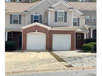 Two-story townhome with brick and siding exterior, two-car garage, and landscaping at 106 Ellis Dr, Conyers, GA 30012