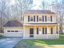 Two-story house featuring a beige exterior, brown roof, and a front porch at 608 Woodknoll Ct, Jonesboro, GA 30238