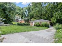 Brick ranch home with a driveway and a grassy yard at 1279 Kenilworth Sw Dr, Atlanta, GA 30310
