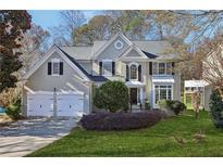 Charming two-story home with a two-car garage, landscaped yard, and mature trees at 185 Witheridge Dr, Johns Creek, GA 30097