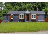 Charming ranch home with gray exterior, wood accents, and manicured lawn at 1544 Childress Sw Dr, Atlanta, GA 30311