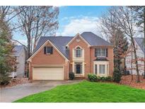 Brick house with a two-car garage and well-maintained lawn at 4830 Chesterfield Ct, Suwanee, GA 30024