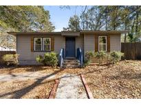 Newly renovated ranch home with blue door and landscaped yard at 501 Aberdeen Nw Dr, Atlanta, GA 30318