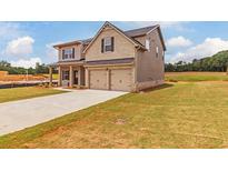 Two-story brick house with two car garage and landscaped lawn at 1621 Fuma Leaf Way, Mcdonough, GA 30253
