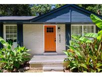 Updated ranch home features a fresh exterior, new landscaping, and inviting orange front door at 8325 Attleboro Dr, Jonesboro, GA 30238