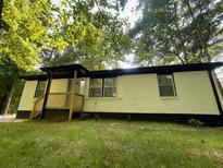 Newly renovated ranch home with white brick, black trim, and a wood deck at 3426 Treadwell Sw Cir, Atlanta, GA 30331