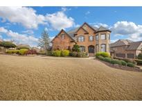 Brick house with stone accents, landscaping, and a large yard at 5435 Cole Creek Ln, Cumming, GA 30040