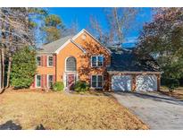 Brick house with a two-car garage and manicured lawn at 1237 Wynford Woods Sw, Marietta, GA 30064