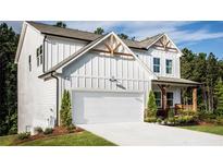 Two-story farmhouse-style home with white siding, large garage, and landscaping at 126 Henley St, Canton, GA 30114