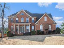 Brick two-story house with a large front yard and manicured landscaping at 2612 Grove Park Ln, Conyers, GA 30094