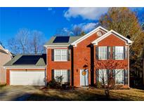 Brick two-story house with solar panels and a two-car garage at 675 Station View Run, Lawrenceville, GA 30043