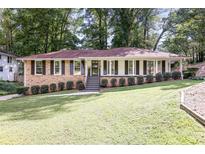 Brick ranch house with a large yard, shutters, and a spacious lawn at 605 Patrick Ne Pl, Sandy Springs, GA 30328