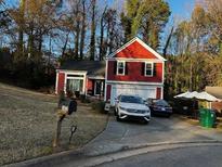 Red two-story house with attached garage and driveway at 7472 Wood Ct, Lithonia, GA 30058