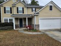 Two-story house with stone accents, a two-car garage, and a landscaped front yard at 1655 Cutleaf Creek Rd, Grayson, GA 30017