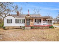 Charming home with a stone and siding exterior, covered porch, and rocking chairs at 8451 Duncan St, Douglasville, GA 30134