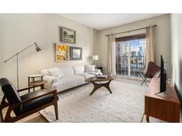 Bright living room features a comfy white sofa and city views at 195 14Th Ne St # 1501, Atlanta, GA 30309