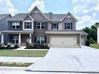 Two-story brick home with a three-car garage and manicured lawn at 1721 Cobblefield Cir, Dacula, GA 30019