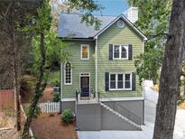 Charming two-story green house with black shutters and a brick staircase at 1900 Harper Nw Rd, Atlanta, GA 30318
