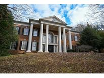 Stately brick home with grand columns and a manicured lawn at 1378 Wesley Oaks Nw Ct, Atlanta, GA 30327