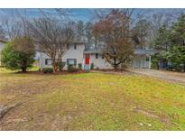 Ranch style home with red door and landscaped lawn at 2761 Whisper Ct, Douglasville, GA 30135