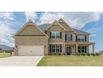 Two-story house with brick and siding, a three-car garage, and a well-manicured lawn at 171 Osier Dr, Mcdonough, GA 30252