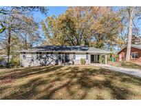 Gray brick ranch house with a spacious yard and driveway at 2126 River Rd, Ellenwood, GA 30294