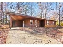 Ranch style home with covered carport and mature trees at 1762 Hunting Creek Se Ln, Conyers, GA 30013