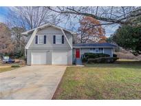 Charming two-story home with gray brick and siding, a red door, and a two-car garage at 1151 Martin Rd, Stone Mountain, GA 30088