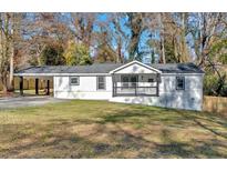 Charming white home with covered carport, front porch, and large yard at 1766 Blossom Ln, Austell, GA 30168