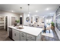 Open concept kitchen features white cabinets, quartz countertops, and stainless steel appliances at 3351 Orwell Way # 2301, Cumming, GA 30041