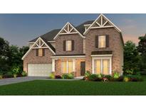 Inviting two-story brick home with a landscaped front yard and warm exterior lighting at 6097 Marigold Way, Atlanta, GA 30349