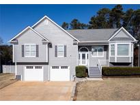 Charming two-story home with a two-car garage, landscaping, and a welcoming front entrance at 1103 Etowah Valley Ln, Woodstock, GA 30189