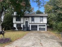 Two-story house with gray and white exterior, attached garage, and landscaping at 981 Dundee Dr, Lilburn, GA 30047